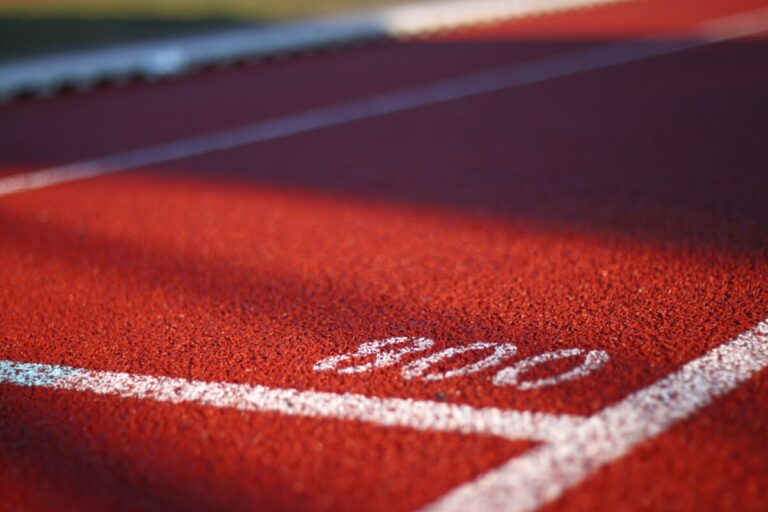 Close up of a red running track with white painted lines and the number 800