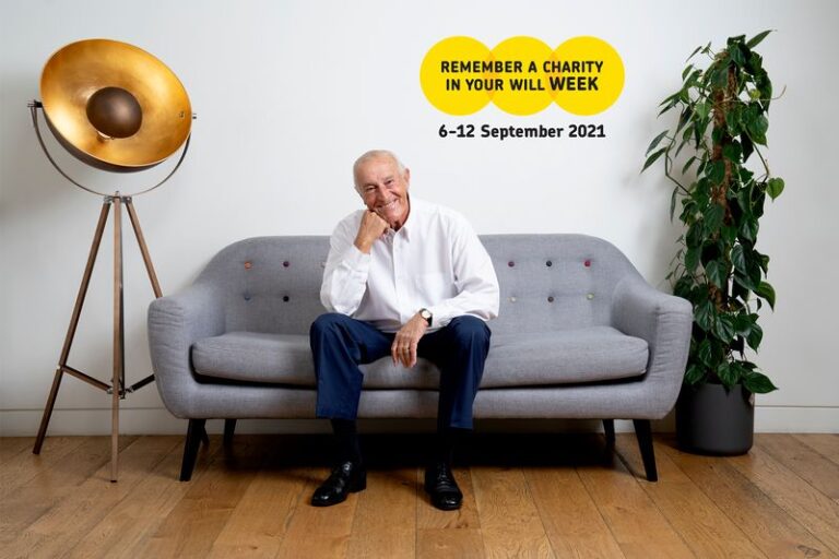 Len Goodman sitting on a grey sofa