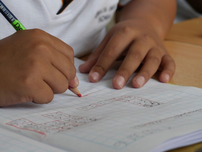 A school child doing maths in their exercise book