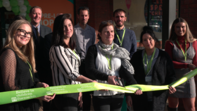 Barnardo's Coventry team cutting a green ribbon to open their superstore