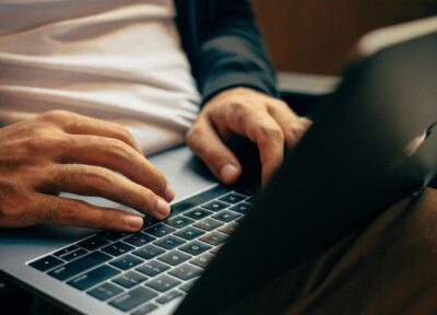 A man typing on a laptop keyboard