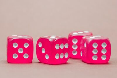 four pink dice against a lighter pink background