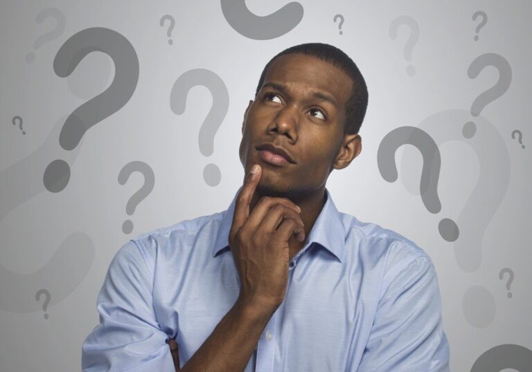 A man in a light blue shirt looks deep in thought, surrounded by question marks