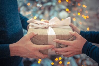a man and a woman pass a christmas present between them