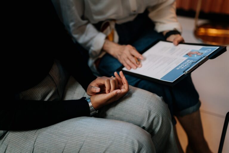 two people sit side by side looking at a CV