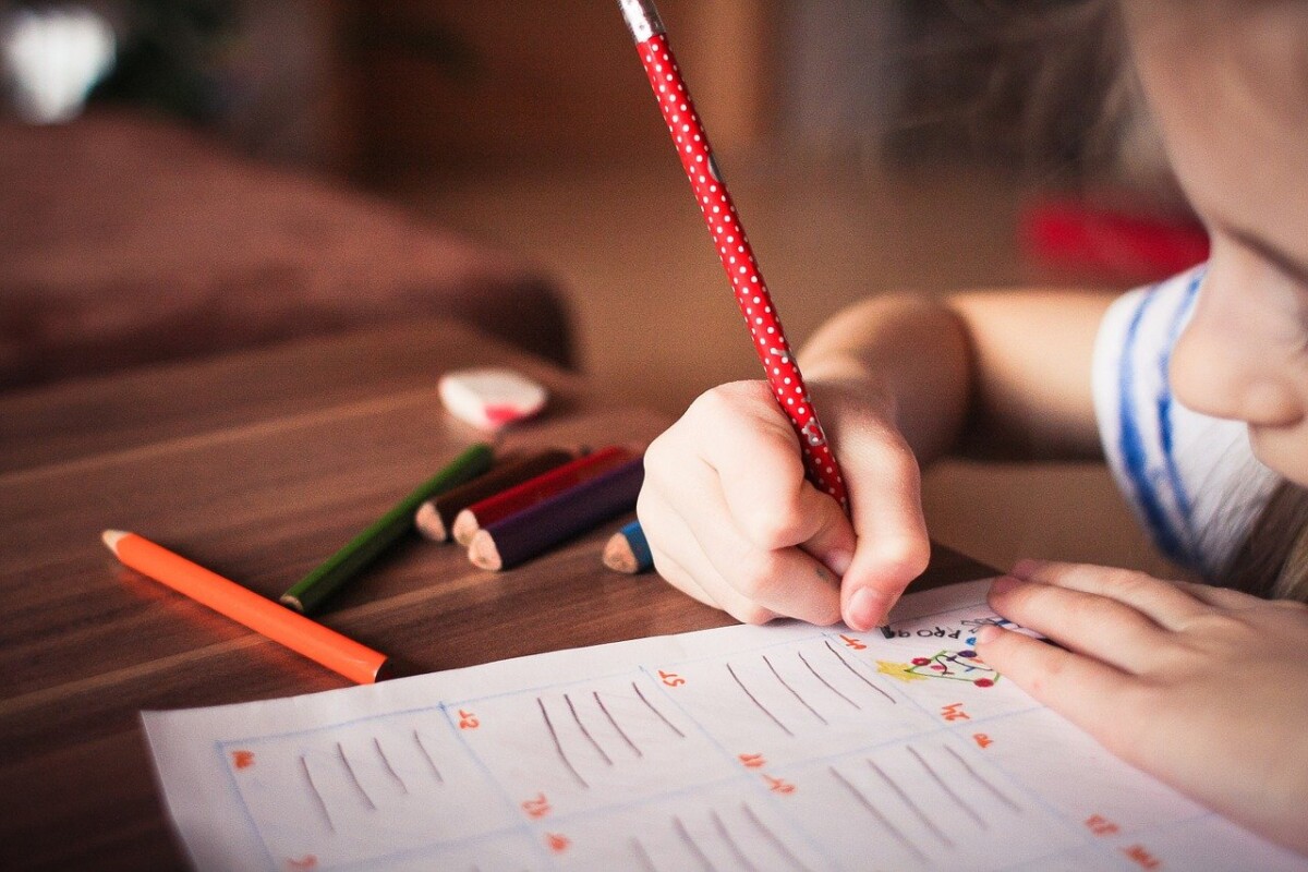 a child drawing with a red pencil