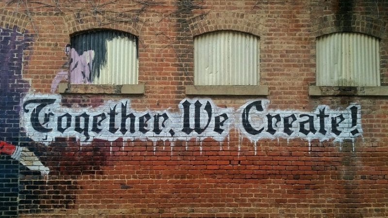 Together We Create. Words painted on the side of a brick building. Unsplash
