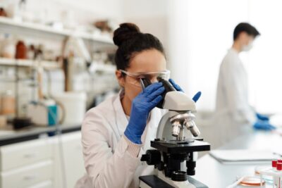 A female scientist looks into a microscope