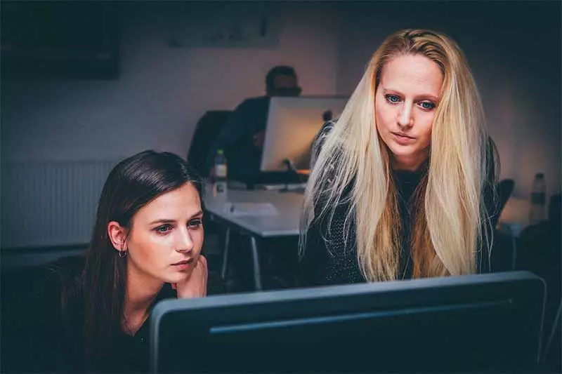 Two women thinking as they look at an office PC. Photo: Pixabay.com