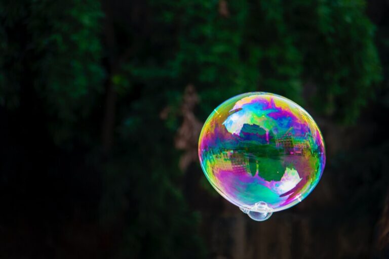 Multi-coloured soap bubble floating in the air against a dark background. Photo: Nick Fewings on Unsplash.com
