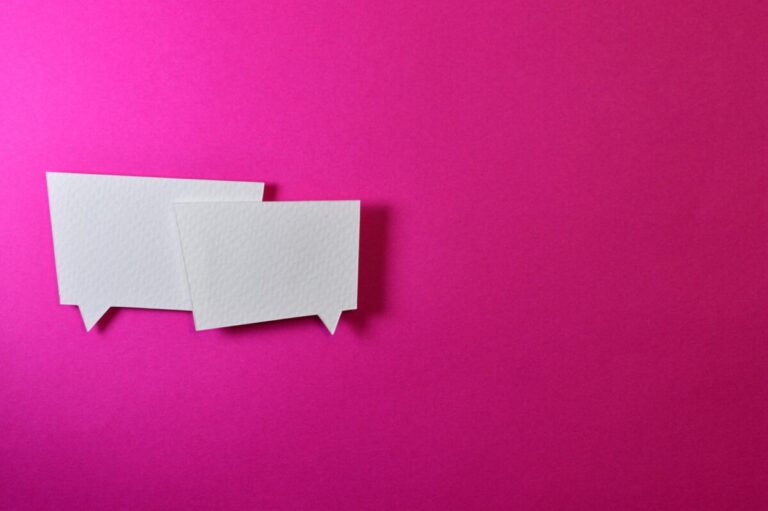 Two paper speech bubbles on a fuchsia background. Image: Pexels.com