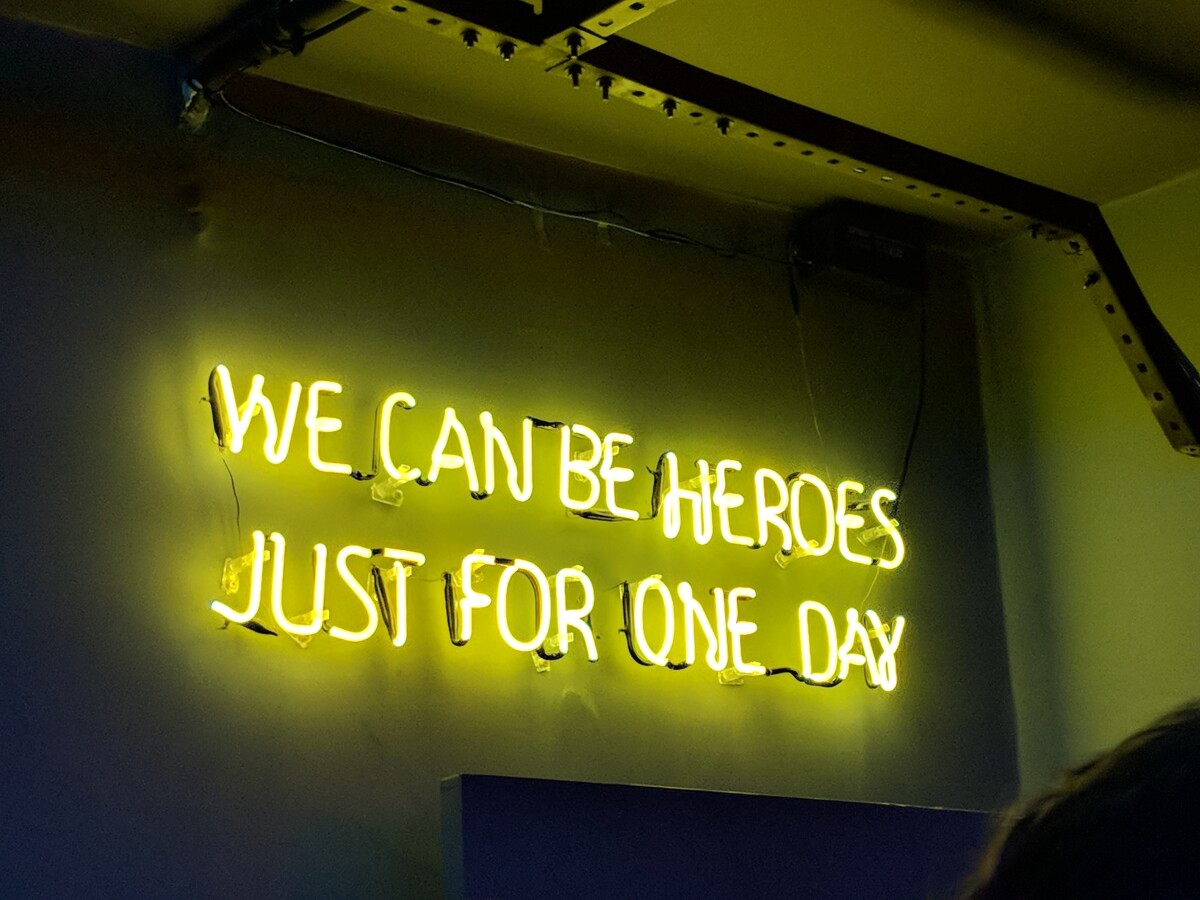Yellow neon sign - "we can be heroes just for one day". Photo: Unsplash.com