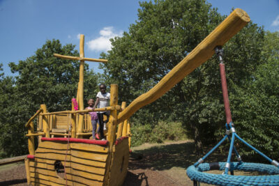 Children play in a wooden boat in an adventure playground