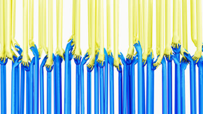 Arms in blue and yellow reaching to hold hands and making the Ukrainian flag