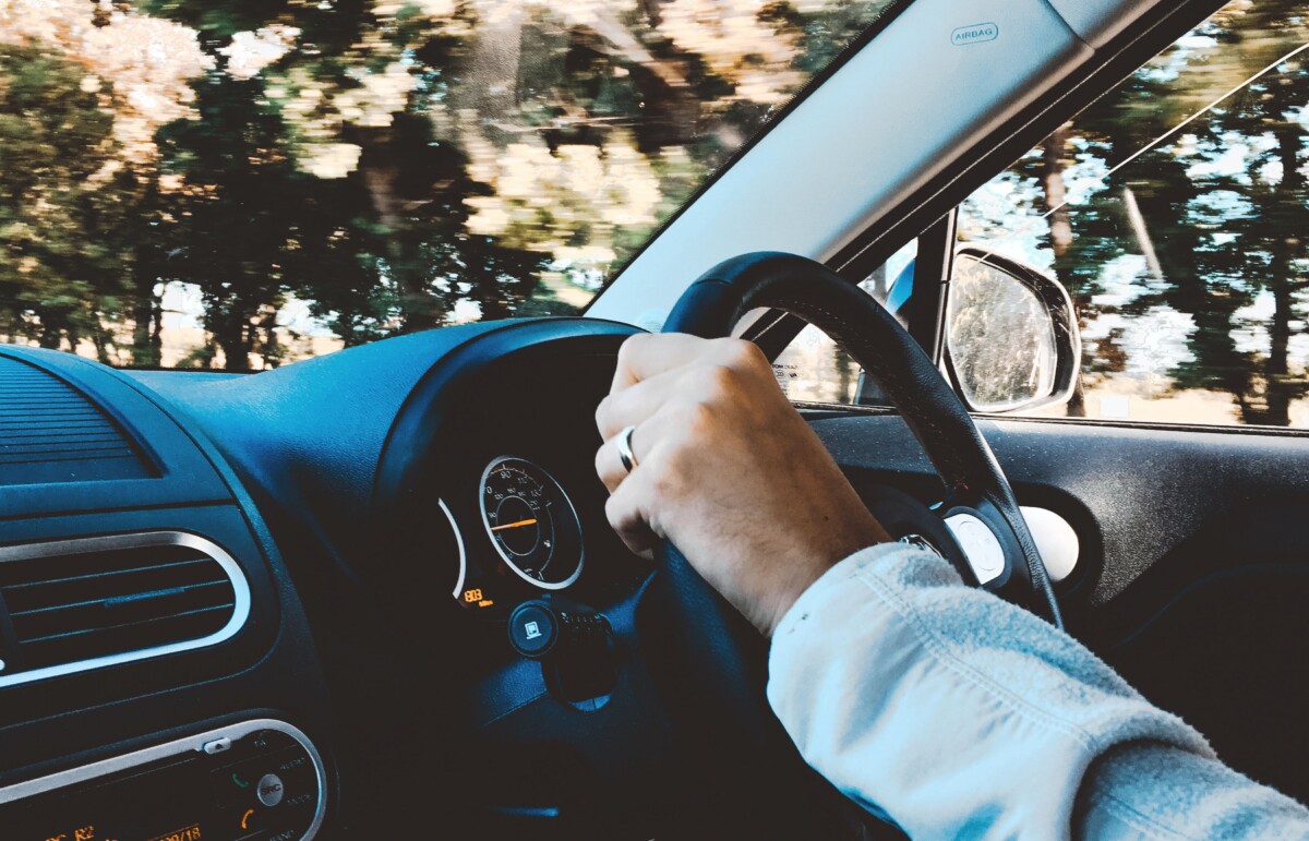 Driving. A woman's hands on the steering wheel in a car