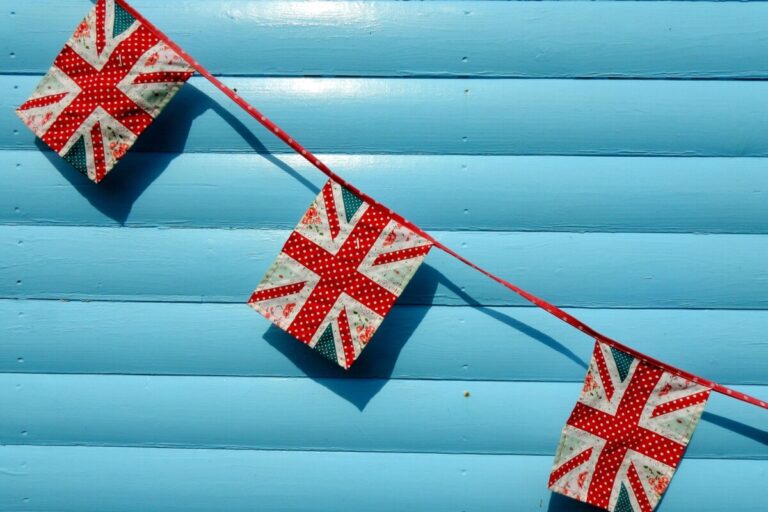 Union flag bunting across a turquoise metal shutter. By Cheap Shot Photo on Pixabay