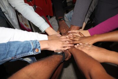 Lots of hands meet in a display of teamwork. By Rinesh Kumar Ghirao on Unsplash