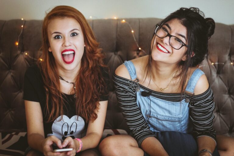 two teenage girls laugh at the camera. Photo by Matheus Ferrero on Unsplash