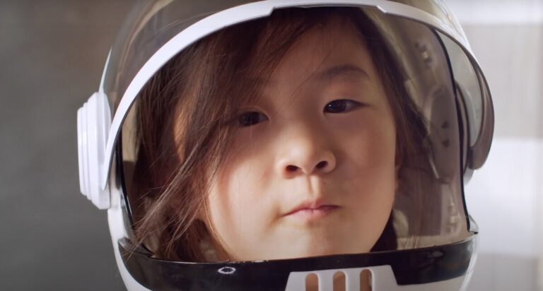 Girl in space helmet - featured still from the Remember A Charity Week video promotion