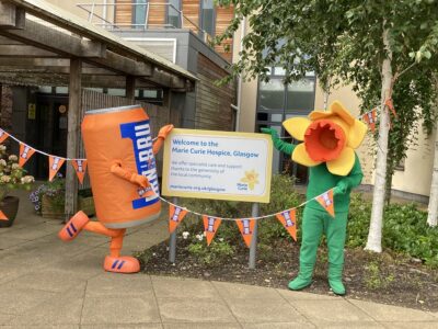 People dressed up as an IRN BRU can & a Marie Curie daffodil outside a marie curie hospice in glasgow