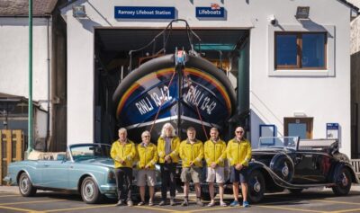 Cars auctioned for the RNLI outside Ramsey RNLI lifeboat station with crew