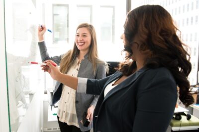 two woman at a whiteboard in an office. By Christina Morillo on Pexels
