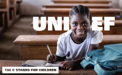 Unicef the C stands for children campaign still showing an African girl in a classroom, smiling at the camera. The word Unicef surrounds her with her head replacing the C