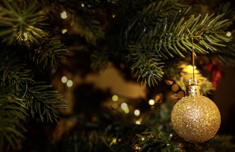A golden glittery bauble on a christmas tree. By Valeria Vinnik on Pexels
