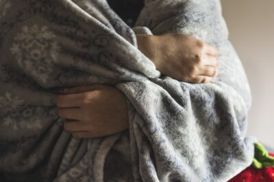 A person wrapped in a grey blanket. by Katrina_S from Pixabay