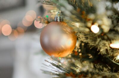 a close up of a gold bauble on a christmas tree. By Element Digital on Pexels