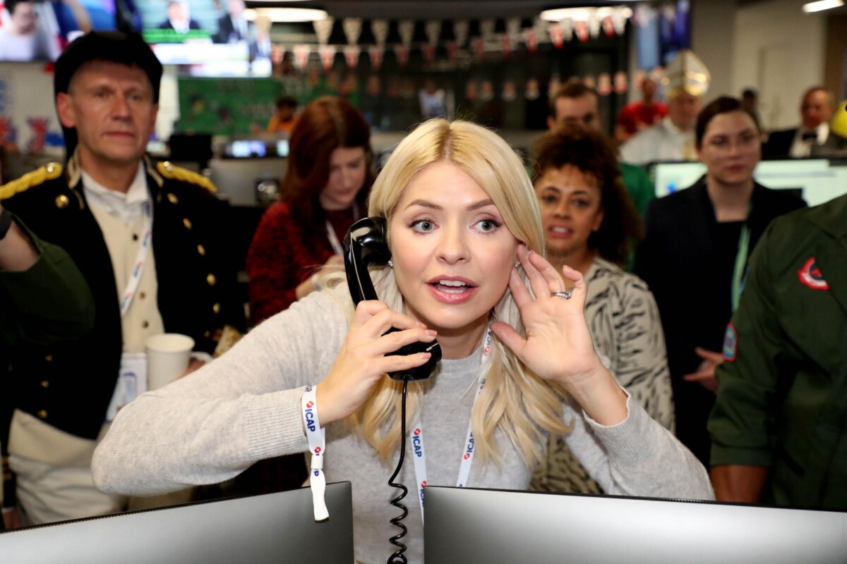 Holly Willoughby at ICAP Charity Day 2022, on the phone by two Mac screens.