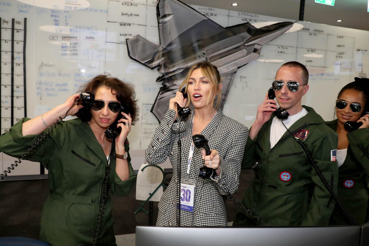 Abbey Clancy at ICAP Charity Day 2022, with brokers in Top Gun fancy dress.
