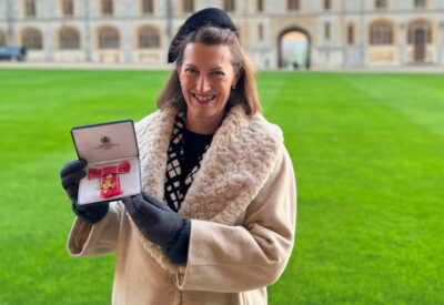 Dr Beth Breeze holds up her OBE