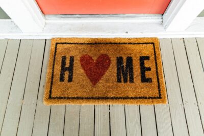 A doormat with the word home on it, and a heart replacing the O