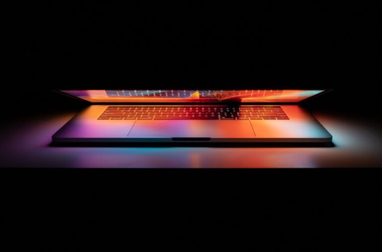 A slightly open laptop throws out a rainbow of colours. Photo by Tianyi Ma on unsplash.
