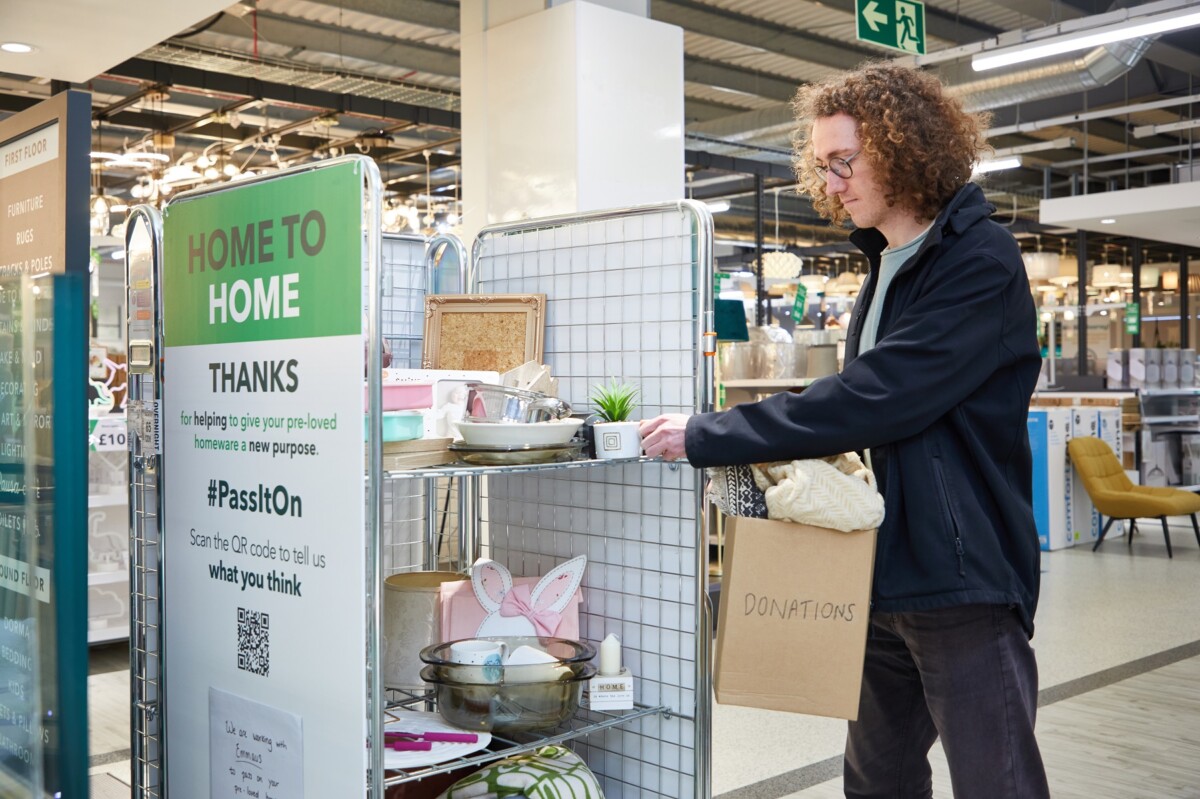 A man donates some unwanted items in a collection area in a Dunelm store as part of Dunelm's Home to Home initiative