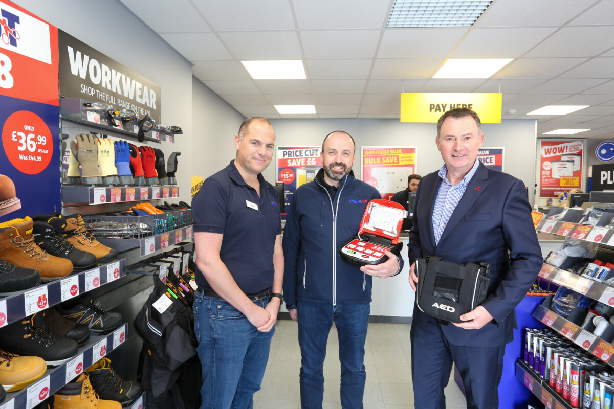 3 men in a Screwfix store in Southampton, with defribrillators that will be installed in a partnership with BHF