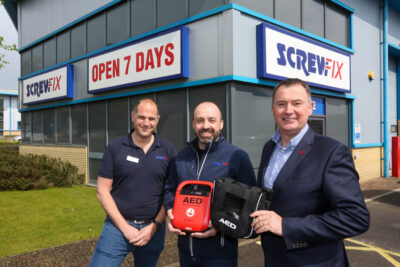 3 men outside a Screwfix store in Southampton, with defribrillators that will be installed in a partnership with BHF
