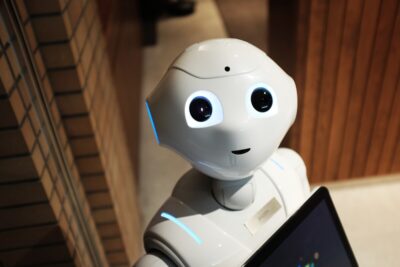 A robot looks up at the camera. By Alex Knight on Pexels