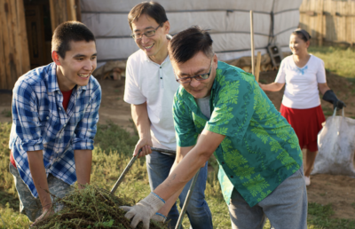 People from the Church of Jesus Christ of Latter-day Saints look joyful as they work in a yard
