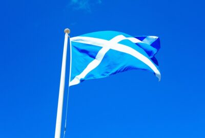 Scottish flag blowing in the breeze against a blue sky