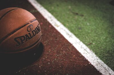 A basketball sits on a court. By Stocksnaps on Pixabay