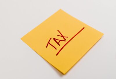 A sticky note with the word tax written on it. By Tara Winstead on Pexels