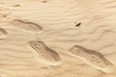 footprints in the sand that say finish cancer - a new campaign from the Institute of Cancer Research
