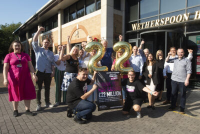 JD Wetherspoon staff with a 22 in balloons, celebrating having raised £22mn for Young Lives vs Cancer