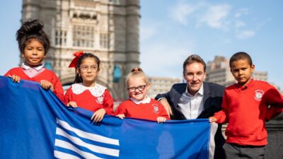 City Bridge Foundation Managing Director David Farnsworth shows off the new City Bridge Foundation flag which will fly over Tower Bridge, with (from left) Nyah, Arisha, Harper and Romeo – Year Three pupils from Charlotte Sharman Primary School, Elephant & Castle