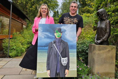 Artist Trevor Jones (right) and Maggie's Edinburgh Fundraising Manager, Samantha Lea (left), holding the NFN Kalyan painting from the event