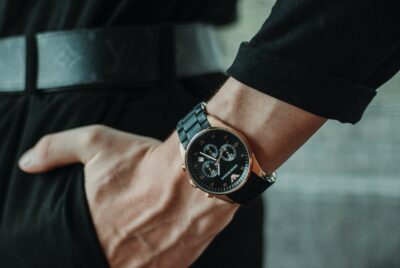 A woman's hand and wrist. Her hand is in her pocket. She wears a black shirt, belt and trousers, and wears a watch. By Eve Maier on Unsplash