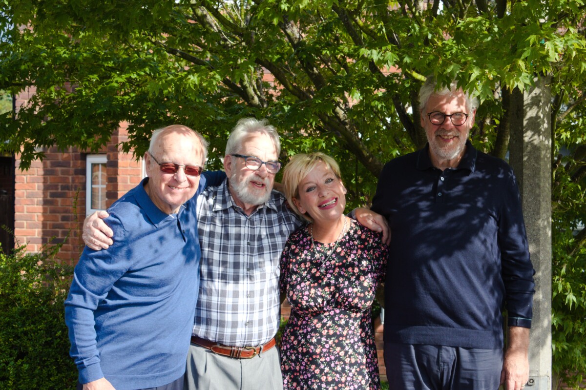 Heart of England Community Foundation people pose for the camera in dappled sunshine, under a tree