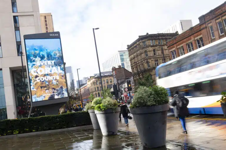 Coral Restoration Foundation advertising on a digital screen on a Manchester street